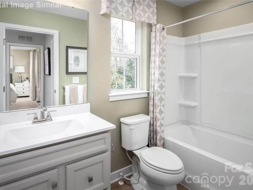 11150 Emerson Landing Drive, Charlotte, NC 28214.  MLS# CAR4367239, YatesRealty ID 40853. Sleek, spacious, and effortlessly stylish—this shared full bath on the upper level is a total showstopper. Natural light pours in through the window, illuminating clean lines and built-in shower shelves that bl