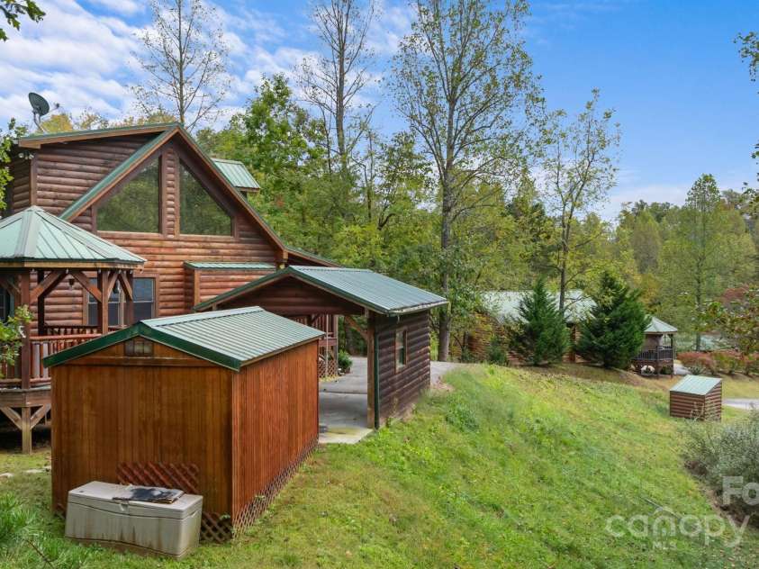 80 Slow Lane, Whittier, NC 28789.  MLS# CAR4307656, YatesRealty ID 4098. View of house, carport and shed from back of lot