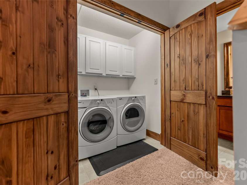 129 Nodatsi Court, Brevard, NC 28712.  MLS# CAR4407587, YatesRealty ID 41149. Lower level washer/dryer in laundry closet with solid wood doors