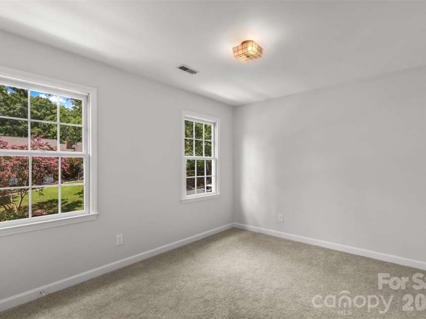7721 Bradenton Drive, Charlotte, NC 28210.  MLS# CAR4408258, YatesRealty ID 41159. Secondary Bedroom – Bright bedroom with expansive windows and a comfortable, airy feel.