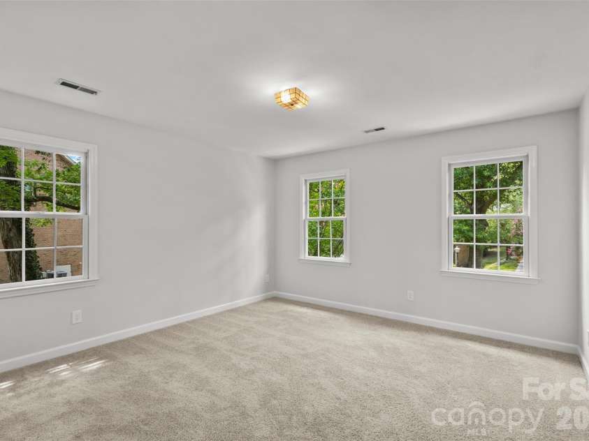 7721 Bradenton Drive, Charlotte, NC 28210.  MLS# CAR4408258, YatesRealty ID 41159. Secondary Bedroom – Spacious bedroom featuring multiple windows, neutral finishes, and abundant natural light.
