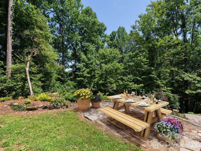 1572 Brushy Fork Road, Sylva, NC 28779.  MLS# CAR4404405, YatesRealty ID 41243. Virtually Staged.Upper patio retreat surrounded by beautifully designed landscape beds, offering a peaceful outdoor escape to enjoy the beauty and serenity of mountain living.