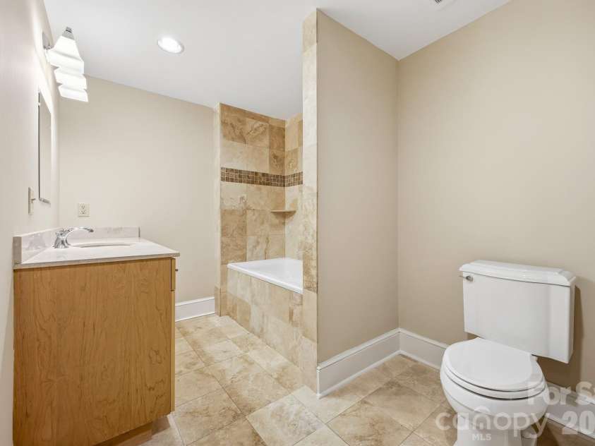 21 Battery Park Avenue, Asheville, NC 28801.  MLS# CAR4366856, YatesRealty ID 4126. Stone Bathroom with Shower and Tub Combo