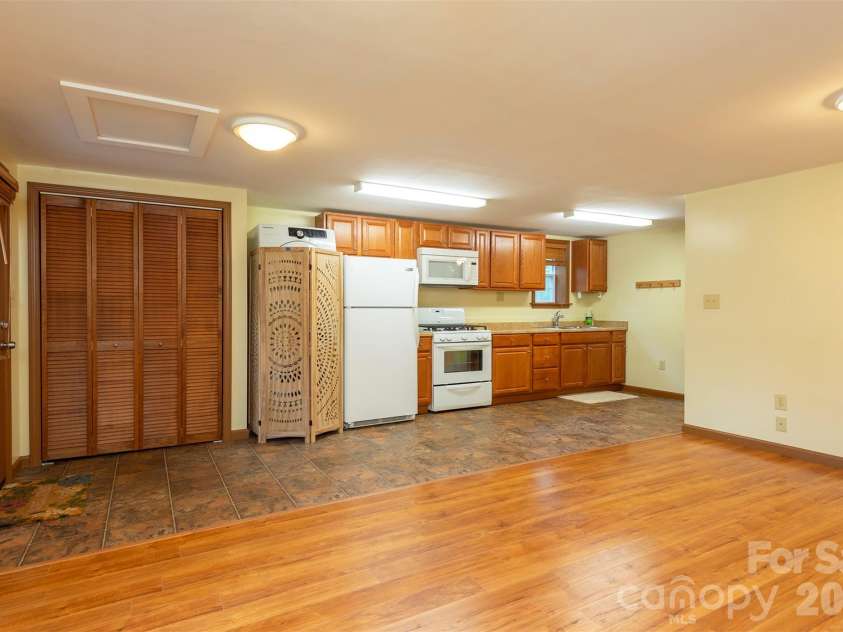 90 Pine Forest Drive, Weaverville, NC 28787.  MLS# CAR4407692, YatesRealty ID 41271. A full kitchen with stackable washer and dryer