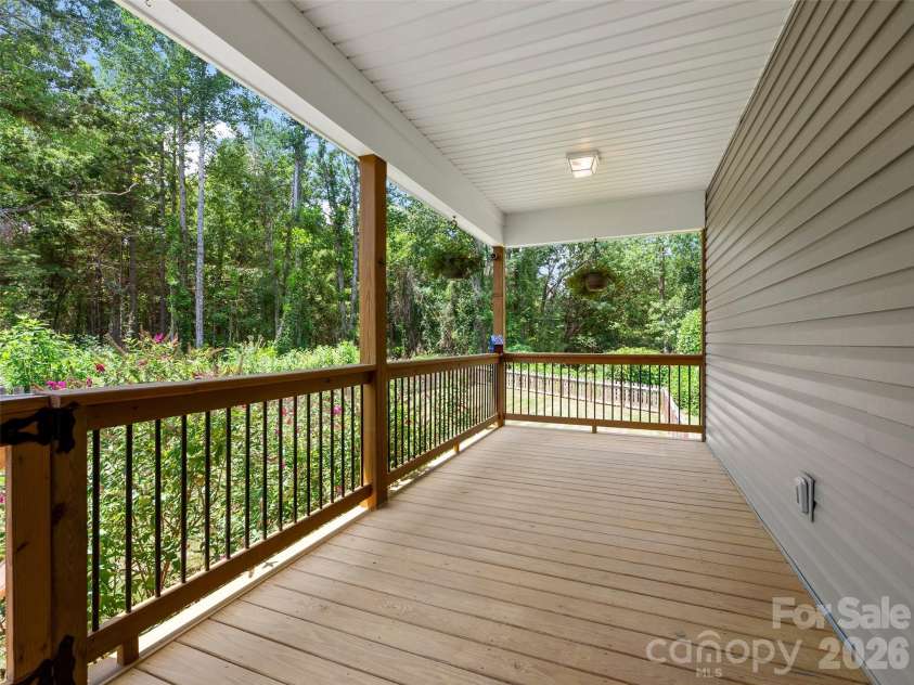201 Mapleton Drive, East Flat Rock, NC 28726.  MLS# CAR4404187, YatesRealty ID 41286. Covered side porch with convenient access to the partially fenced yard, creating an inviting outdoor space to enjoy morning coffee, relax, entertain, or unwind while enjoying the fresh air.