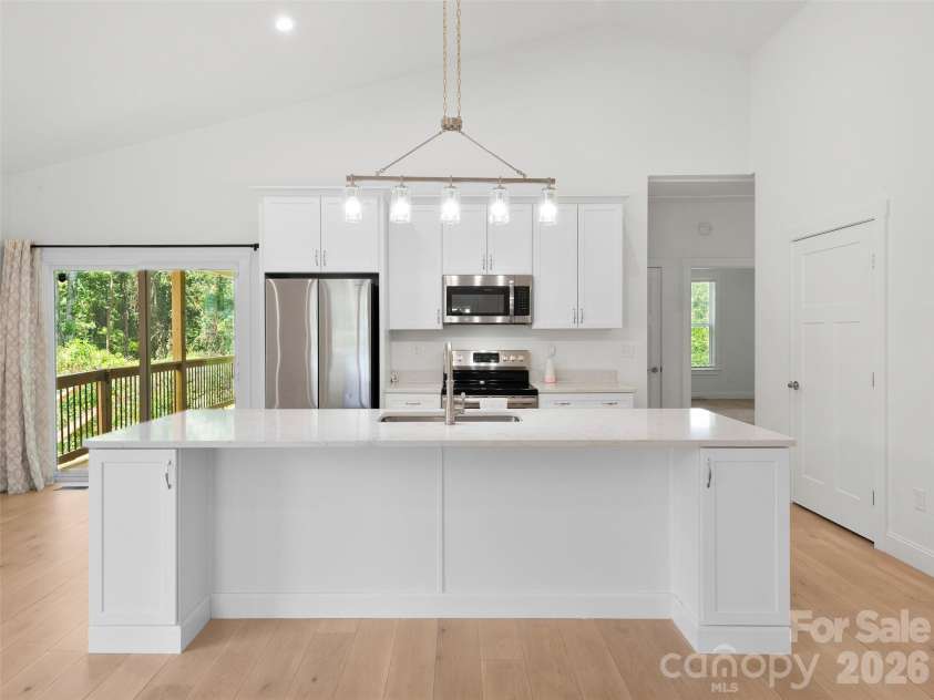 201 Mapleton Drive, East Flat Rock, NC 28726.  MLS# CAR4404187, YatesRealty ID 41286. Open floor plan featuring a spacious kitchen with island, beautiful stainless steel appliances, and refrigerator included. The inviting layout is perfect for everyday living and entertaining.