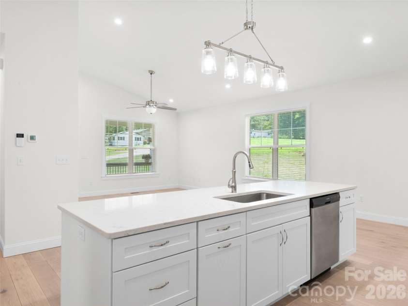 201 Mapleton Drive, East Flat Rock, NC 28726.  MLS# CAR4404187, YatesRealty ID 41286. The spacious kitchen island features a stainless steel sink, providing ample workspace for meal preparation, entertaining, and everyday convenience.