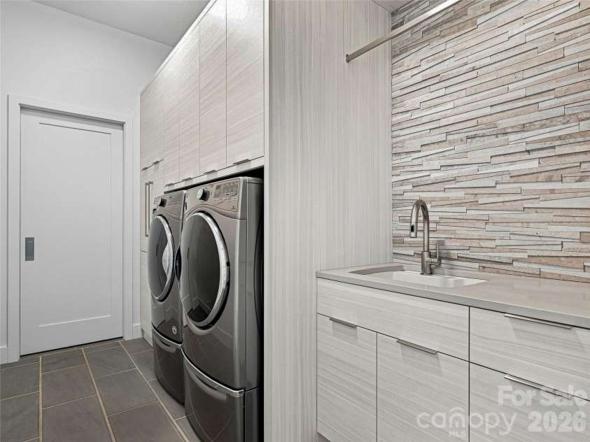 25 Bartrams Walk Drive, Asheville, NC 28804.  MLS# CAR4402146, YatesRealty ID 41418. The laundry room has a sink and storage