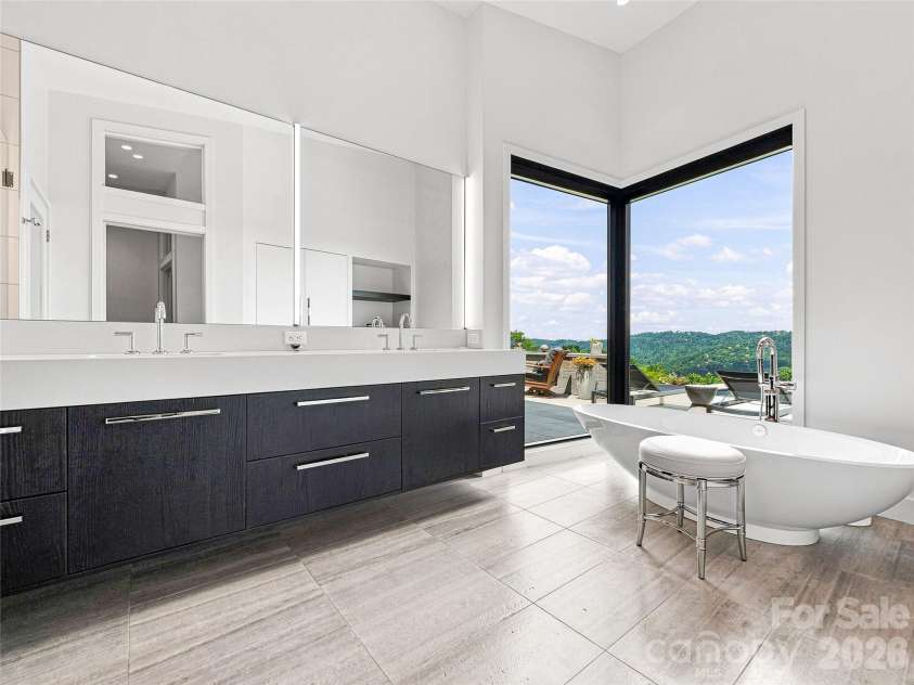 25 Bartrams Walk Drive, Asheville, NC 28804.  MLS# CAR4402146, YatesRealty ID 41418. The spacious spa like primary bath has a spacious walk-in shower and custom storage.