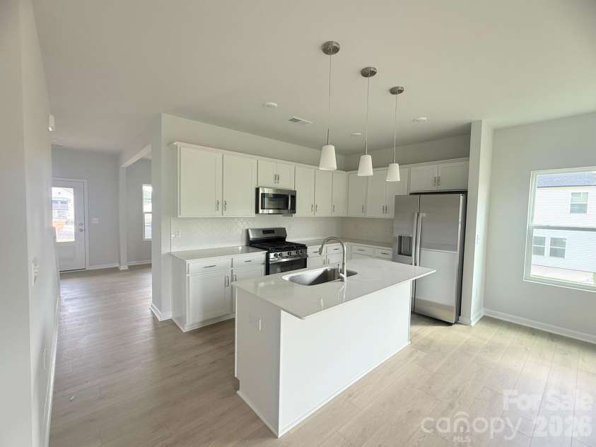 4013 Juno Drive, Charlotte, NC 28215.  MLS# CAR4407718, YatesRealty ID 41547. Kitchen features White Cabinets and Quartz Countertops with a herringbone white tile backsplash