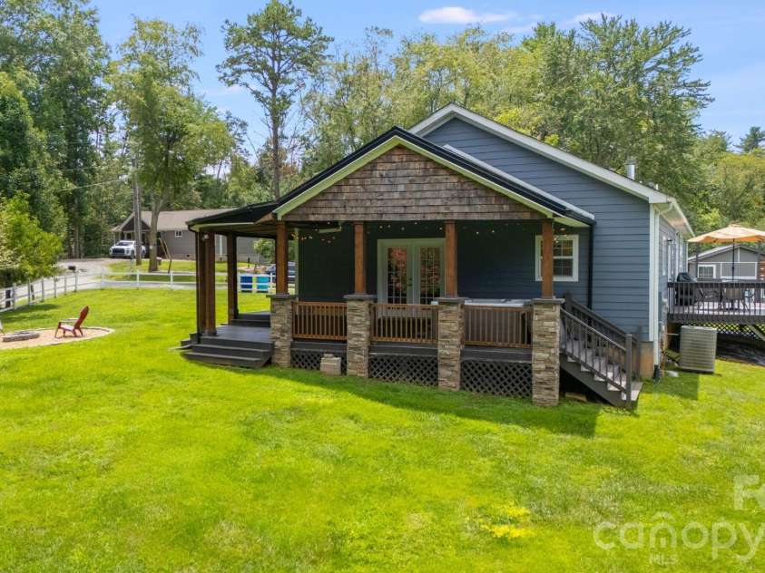 21 Old Pinner Place, Arden, NC 28704.  MLS# CAR4407827, YatesRealty ID 41672. Side of home with beautiful fire pit