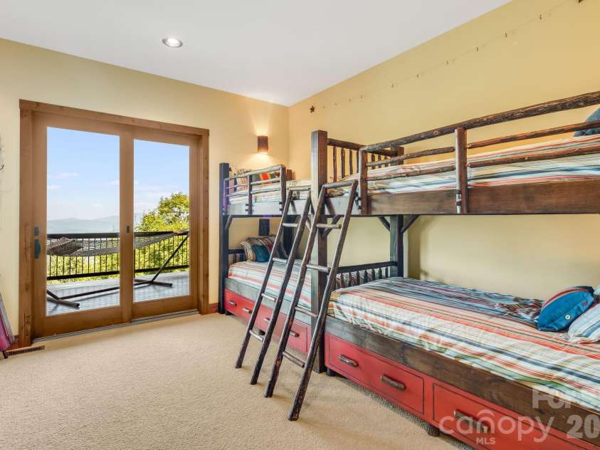 817 Running Cedar Lane, Mars Hill, NC 28754.  MLS# CAR4407984, YatesRealty ID 42073. Bedroom 4 is a spacious bunk room with custom rustic bunk beds, double doors opening to the mountain air and long range views.