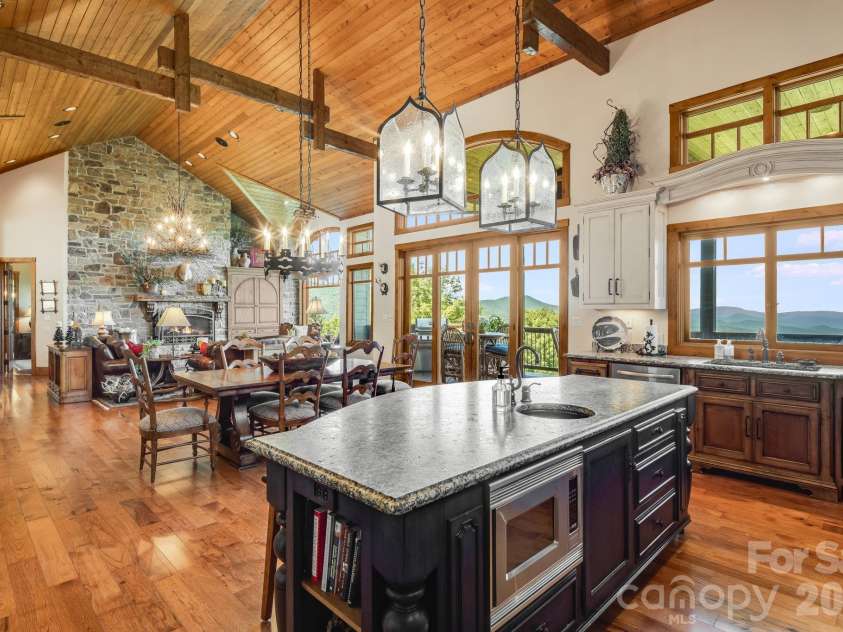 817 Running Cedar Lane, Mars Hill, NC 28754.  MLS# CAR4407984, YatesRealty ID 42073. The expansive kitchen opens effortlessly to the dining area and great room, with a generous granite island, soaring wood ceilings, exposed timber rafters and long-range Blue Ridge Mountain views creating an exceptio