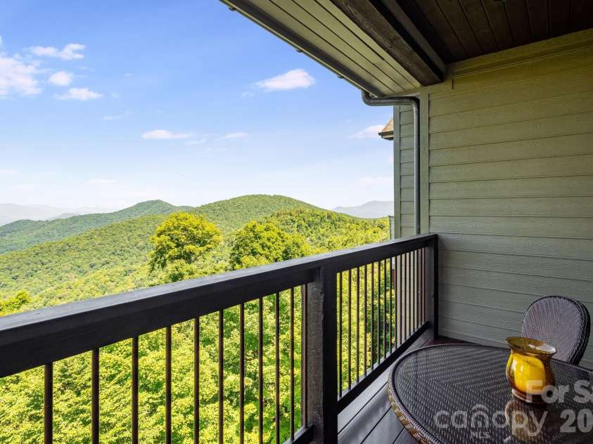 817 Running Cedar Lane, Mars Hill, NC 28754.  MLS# CAR4407984, YatesRealty ID 42073. The primary suite’s private covered balcony provides an intimate setting for morning coffee, quiet reflection and breathtaking long-range mountain views.