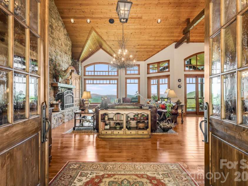 817 Running Cedar Lane, Mars Hill, NC 28754.  MLS# CAR4407984, YatesRealty ID 42073. The stunning double front doors open to a dramatic great room, where soaring ceilings, warm woodwork, natural stone and long-range Blue Ridge Mountain views create an unforgettable first impression.