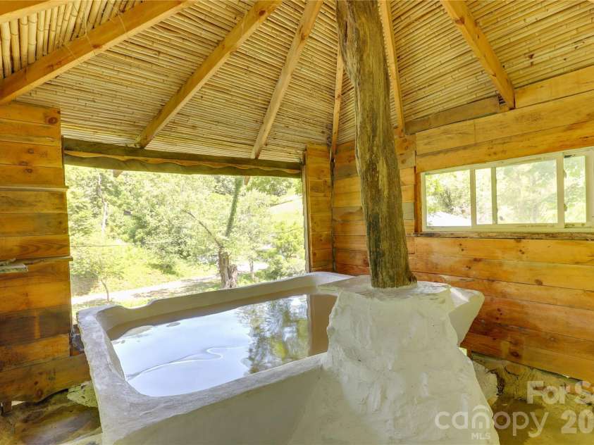 435 Mountain Cove Road, Marshall, NC 28753.  MLS# CAR4396478, YatesRealty ID 42077. Concrete built soaking tub fired by wood or kept cold