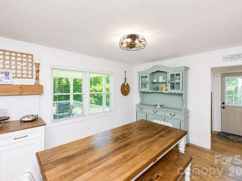 2221 New Hope Church Road, Chester, SC 29706.  MLS# CAR4387251, YatesRealty ID 42092. White custom cabinets convey and include a pull-out trash can.  They are not affixed, allowing them to be moved if desired to showcase the original location of the home's charming wood-burning stove.