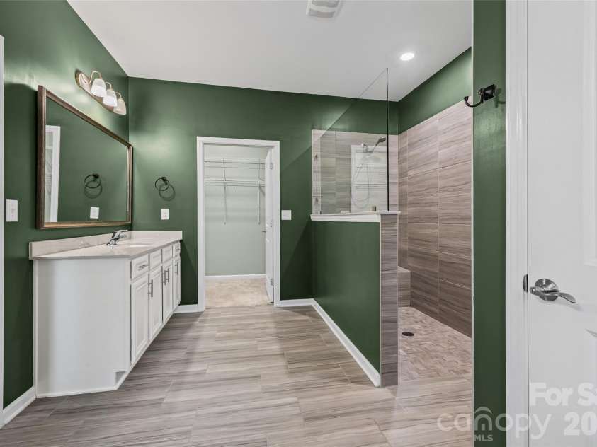 596 Rustlewood Way, Rock Hill, SC 29732.  MLS# CAR4409855, YatesRealty ID 42174. Spa-like primary ensuite featuring dual vanities and an oversized zero-entry walk-in shower—perfect for relaxing and unwinding at the end of the day.