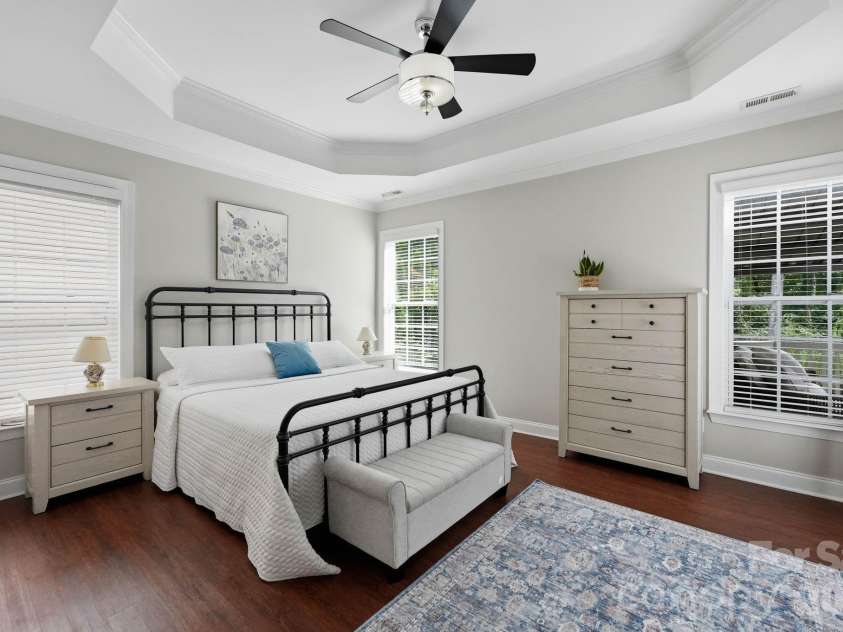 18609 Boulder Rock Loop, Davidson, NC 28036.  MLS# CAR4411962, YatesRealty ID 42335. Light-filled primary bedroom suite featuring an elegant tray ceiling and ceiling fan.