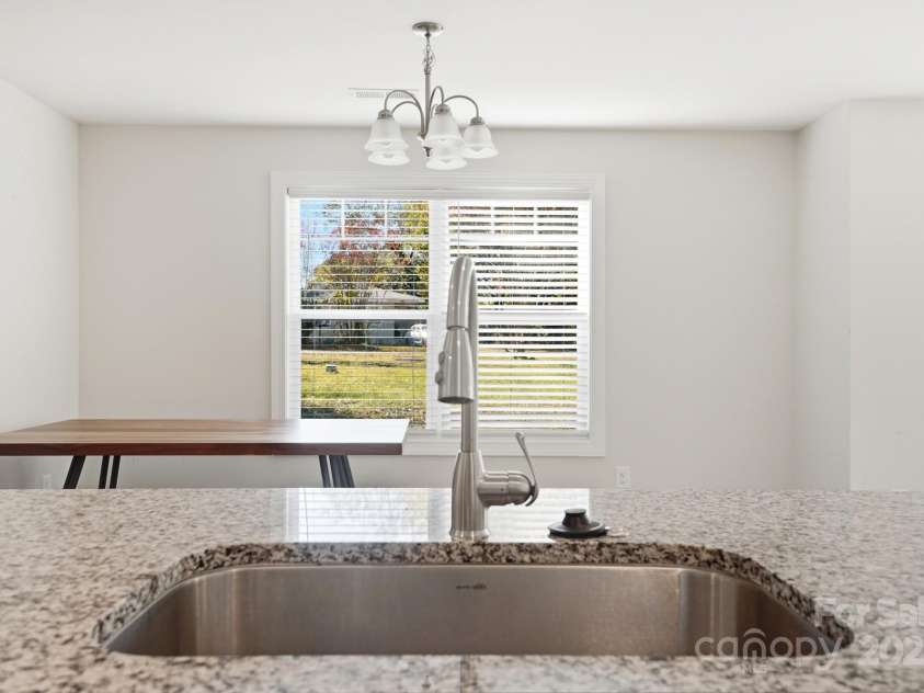 351 Center Street, Kannapolis, NC 28083.  MLS# CAR4304032, YatesRealty ID 4248. A beautiful granite countertop with an undermount stainless steel sink and gooseneck faucet provides a perfect view of the bright dining area and backyard