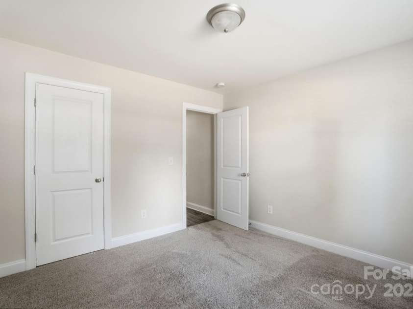 351 Center Street, Kannapolis, NC 28083.  MLS# CAR4304032, YatesRealty ID 4248. Another bright secondary bedroom provides a soft carpeted floor, a neutral color scheme, and two clean white six-panel doors for closet and hallway access