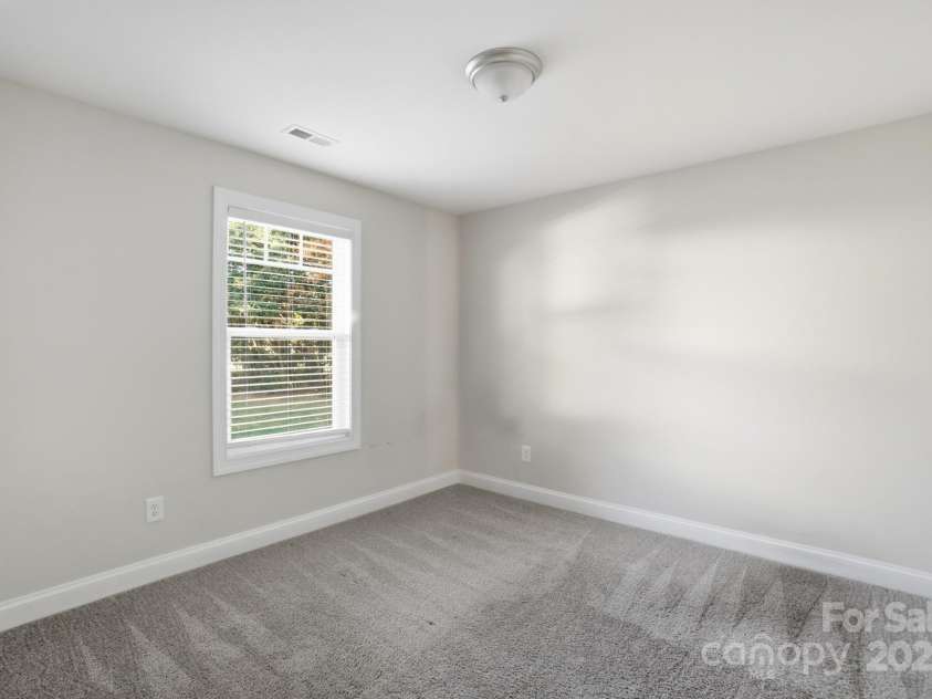 351 Center Street, Kannapolis, NC 28083.  MLS# CAR4304032, YatesRealty ID 4248. Another well-appointed secondary bedroom features a neutral paint scheme, comfortable grey carpeting, and a window that provides beautiful natural light