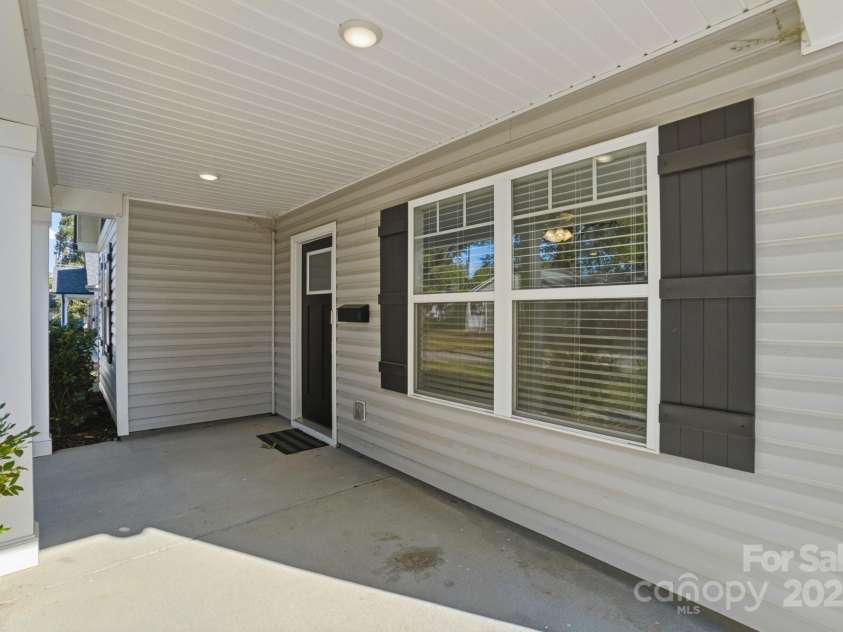 351 Center Street, Kannapolis, NC 28083.  MLS# CAR4304032, YatesRealty ID 4248. Relax and enjoy the outdoors on the spacious covered front porch, featuring modern vinyl siding, recessed lighting, and large front windows with dark grey decorative shutters