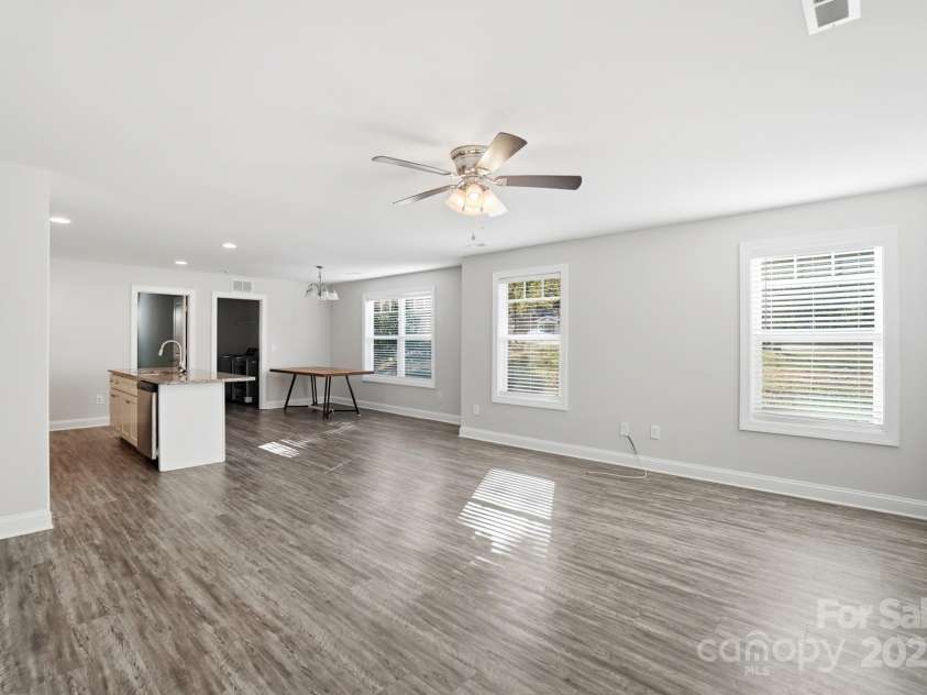 351 Center Street, Kannapolis, NC 28083.  MLS# CAR4304032, YatesRealty ID 4248. The expansive open-concept living area features abundant natural light, stylish wood-look vinyl plank flooring, and a modern brushed nickel ceiling fan, perfect for entertaining and daily life