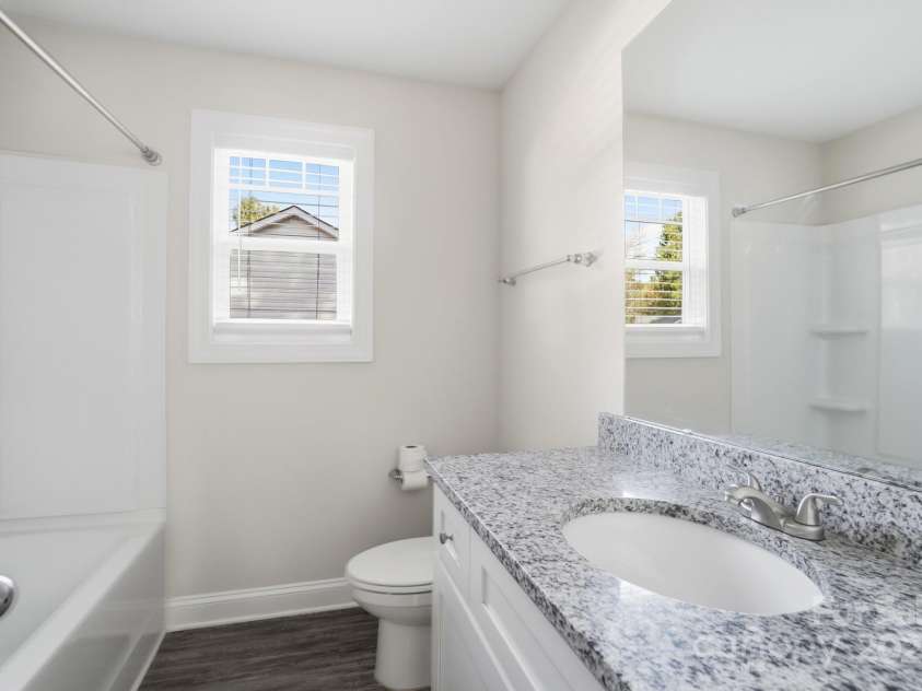351 Center Street, Kannapolis, NC 28083.  MLS# CAR4304032, YatesRealty ID 4248. The guest bathroom is finished with a modern flair, featuring a granite vanity, bright white cabinetry, and a clean shower/tub combination