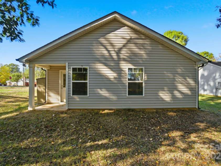 351 Center Street, Kannapolis, NC 28083.  MLS# CAR4304032, YatesRealty ID 4248. The rear exterior showcases the home's modern vinyl siding, two bright windows, and the convenient covered back porch entrance under a sunny blue sky