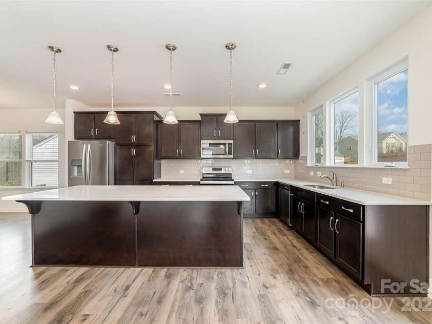 2522 Andes Drive, Statesville, NC 28625.  MLS# CAR4238678, YatesRealty ID 4254. Kitchen with Stainless Steel Appliances, Ample Cabinetry, Oversized Island with Quartz Countertops, 4 Pendant Lights, Subway Tile Backsplash