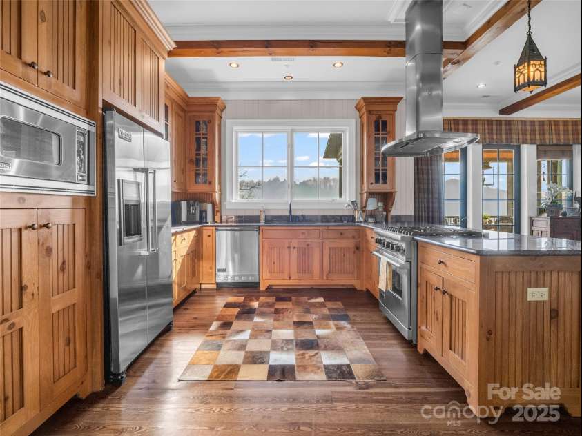 305 Clubhouse Lane, Mill Spring, NC 28756.  MLS# CAR4241690, YatesRealty ID 4258. State-of-the-art appliances, and an abundance of custom storage solutions, this kitchen combines both style and functionality to create a culinary haven.