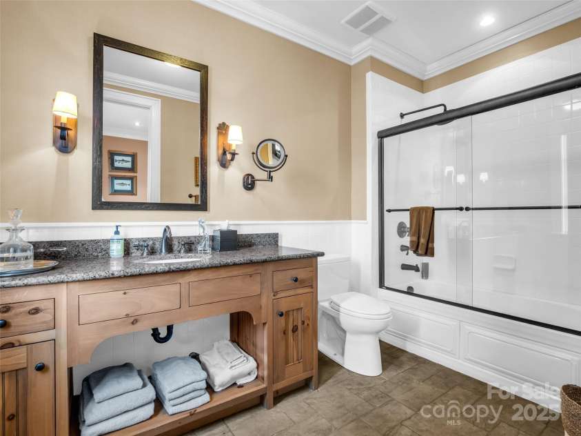 305 Clubhouse Lane, Mill Spring, NC 28756.  MLS# CAR4241690, YatesRealty ID 4258. Stylish vanity, tub/shower combo and high-end finishes in this private bathroom off the second ensuite.