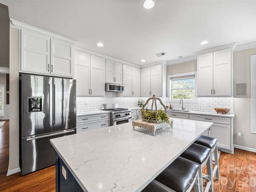 8621 Sequoia Grove Lane, Charlotte, NC 28214.  MLS# CAR4407064, YatesRealty ID 42751. Gorgeous updated kitchen with tall cabinets, tiled backsplash and a generous kitchen island with barstool seating.