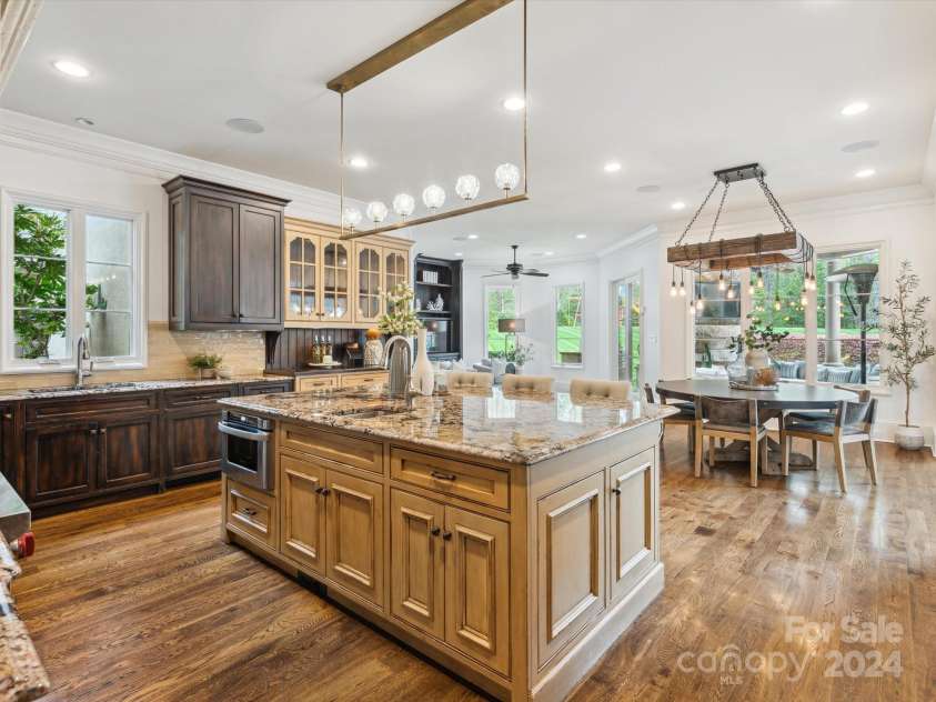 9044 Island Point Road, Charlotte, NC 28278.  MLS# CAR4135509, YatesRealty ID 428. Explore the expansive, open-concept custom kitchen, adorned with exquisite finishes and seamlessly extending into the main living room. This space affords unobstructed views of the luxurious pool and meticulously land