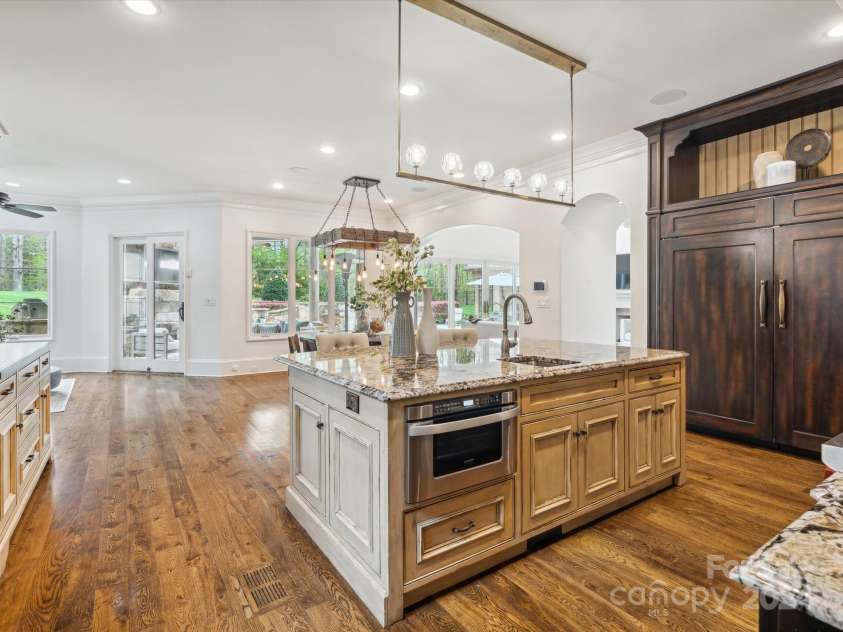9044 Island Point Road, Charlotte, NC 28278.  MLS# CAR4135509, YatesRealty ID 428. Explore the expansive, open-concept custom kitchen, adorned with exquisite finishes and seamlessly extending into the main living room. This space affords unobstructed views of the luxurious pool and meticulously land