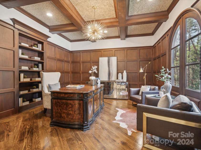 9044 Island Point Road, Charlotte, NC 28278.  MLS# CAR4135509, YatesRealty ID 428. The executive study, a testament to exquisite craftsmanship, featuring bespoke wood coffered ceilings and paneling that underscore the meticulous attention to detail inherent in its construction.