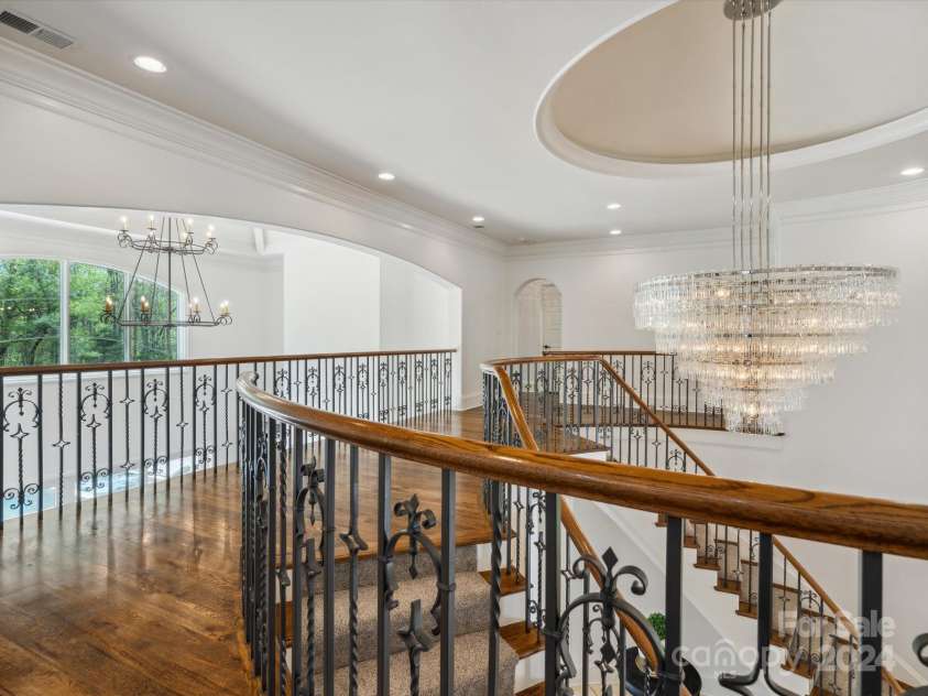 9044 Island Point Road, Charlotte, NC 28278.  MLS# CAR4135509, YatesRealty ID 428. The second-floor main hallway, which offers a commanding view of both the grand foyer and living room below. Adorned with custom arches and a magnificent chandelier that bathes the space in light, this area radiates a
