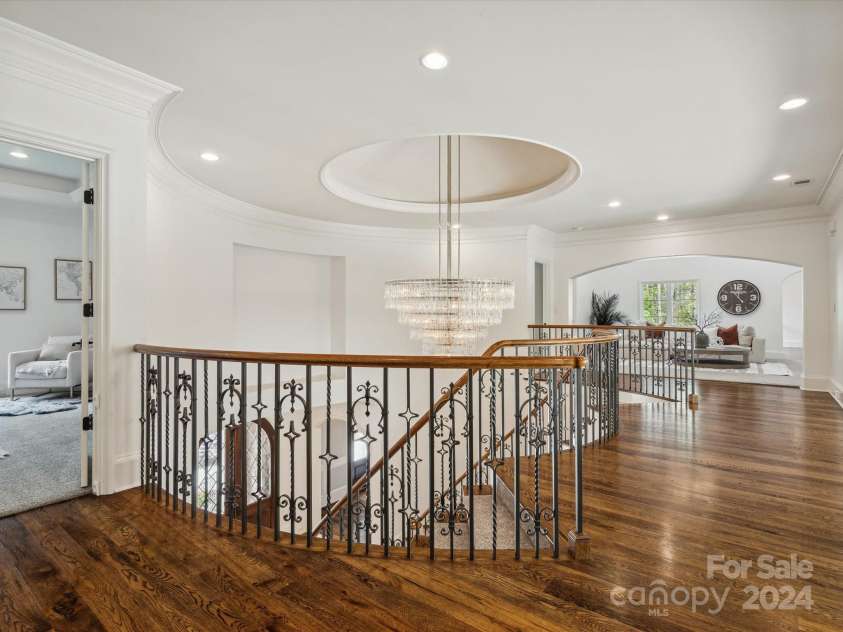 9044 Island Point Road, Charlotte, NC 28278.  MLS# CAR4135509, YatesRealty ID 428. The second-floor main hallway, which offers a commanding view of both the grand foyer and living room below. Adorned with custom arches and a magnificent chandelier that bathes the space in light, this area radiates a