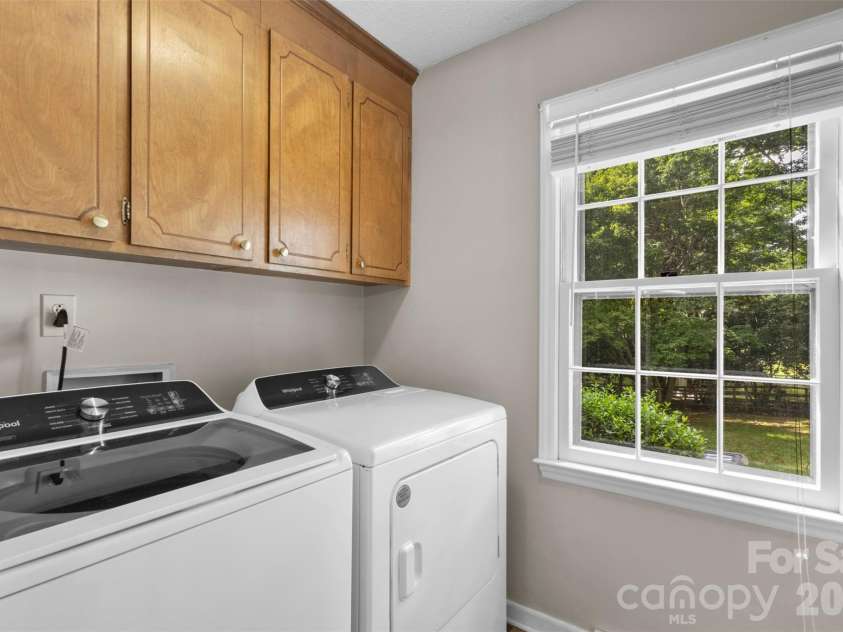 3022 Butter Churn Lane, Matthews, NC 28105.  MLS# CAR4411109, YatesRealty ID 43021. Laundry Room – Dedicated laundry room with upper cabinetry for additional storage and a large window for natural light.