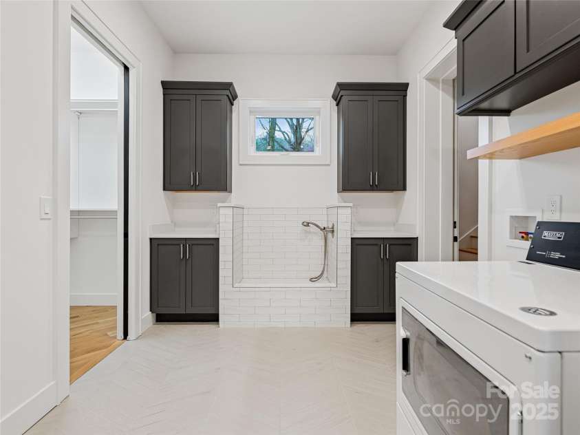 165 Robinhood Road, Asheville, NC 28804.  MLS# CAR4240751, YatesRealty ID 4309. Designed for real life—this mudroom includes a dog wash station, laundry space, built-in cubbies, and a walk-in storage closet