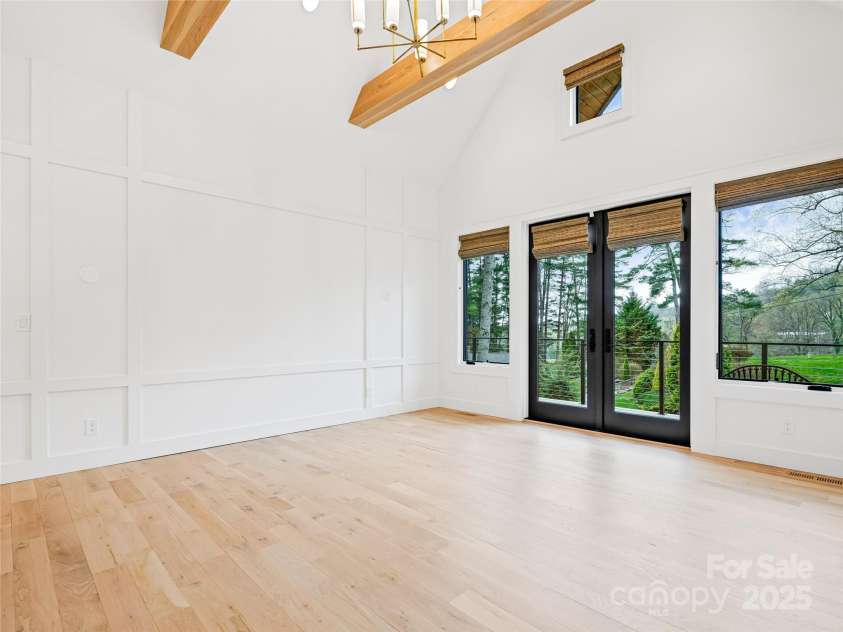 165 Robinhood Road, Asheville, NC 28804.  MLS# CAR4240751, YatesRealty ID 4309. Spacious primary suite with vaulted ceilings, exposed wood beams, and direct access to the sundeck with golf course views