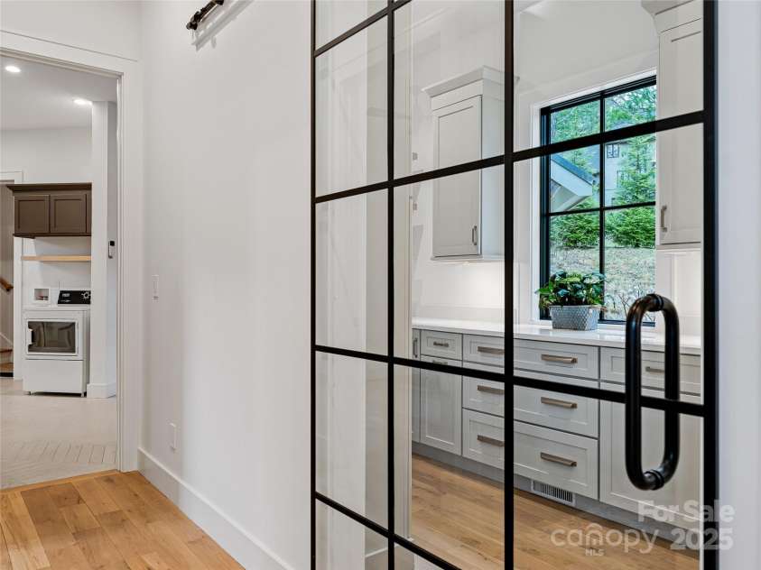 165 Robinhood Road, Asheville, NC 28804.  MLS# CAR4240751, YatesRealty ID 4309. Spacious walk-in butler’s pantry with a sleek glass barn door, abundant storage, and ample workspace