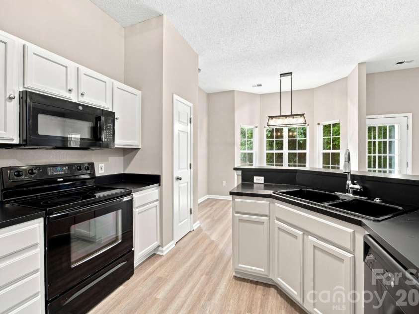 7632 Free Bird Avenue, Charlotte, NC 28216.  MLS# CAR4411446, YatesRealty ID 43281. White cabinets with black counters and black appliances- feels current and move-in ready