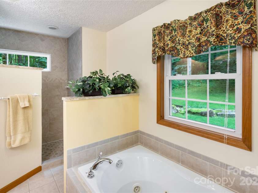 93 Hickory Drive, Maggie Valley, NC 28751.  MLS# CAR4290605, YatesRealty ID 4338. Relaxing soaking tub in primary bathroom
