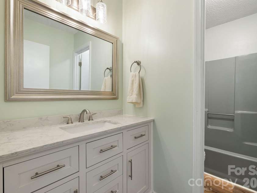 35 Golden Oaks Lane, Fletcher, NC 28732.  MLS# CAR4411250, YatesRealty ID 43415. Updated hall bath conveniently serves the secondary bedrooms.
