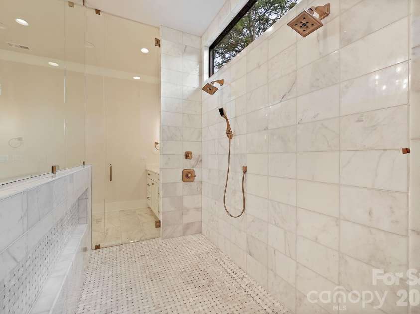 21617 Rio Oro Drive, Cornelius, NC 28031.  MLS# CAR4411277, YatesRealty ID 43438. Floor to ceiling marble, a spacious glass inclosed zero entry shower and hidden over-sized niche!