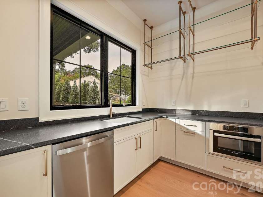 21617 Rio Oro Drive, Cornelius, NC 28031.  MLS# CAR4411277, YatesRealty ID 43438. No luxry home is complete without a 'messy kitchen' that offers a second dishwasher, double trash pull out, microwave, luxury floating shelves, and Vincent black honed quartz countertops.