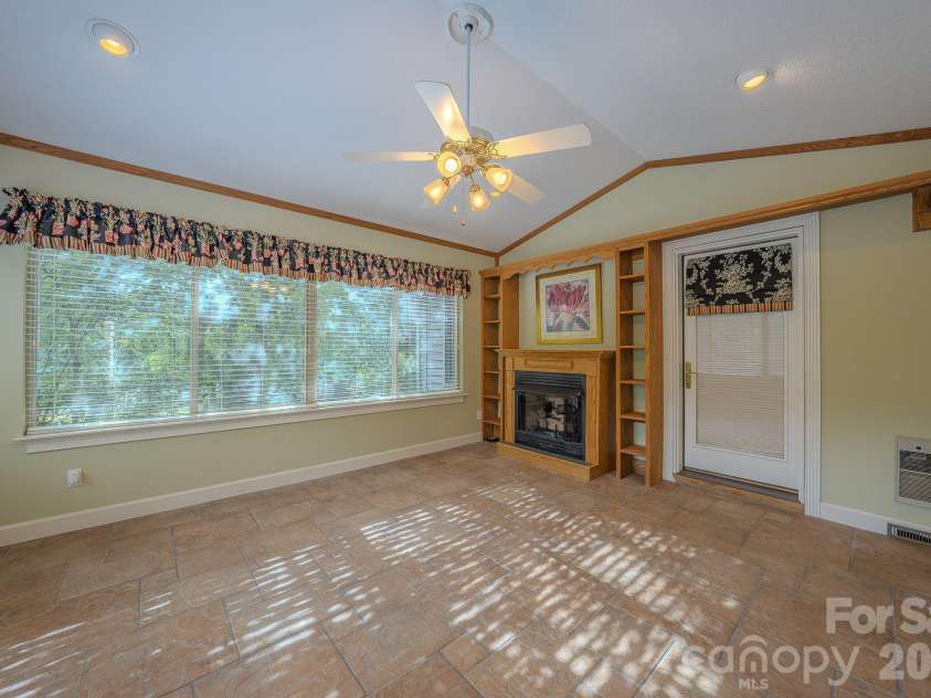 5 Kari Circle, Candler, NC 28715.  MLS# CAR4412820, YatesRealty ID 43469. Sunroom with fireplace