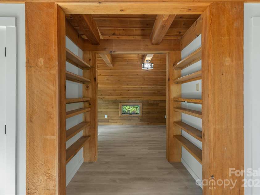 1679 Woods Mountain Trail, Cullowhee, NC 28723.  MLS# CAR4206125, YatesRealty ID 4351. Built-in bookshelf-lined hallway